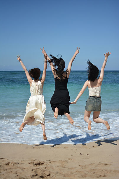 three energetic women jumping at the beach