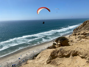 A person gliding near the cliffs of Torrey Pines Beach in San Diego