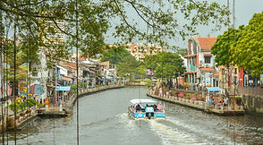 A river boat on the Melaka River lined with heritage buildings
