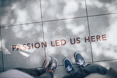 Marketing Selbstständige - Zwei Frauen stehen vor einem Schriftzug "Passion Led Us Here"