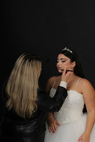 Makeup artist applying makeup to bride