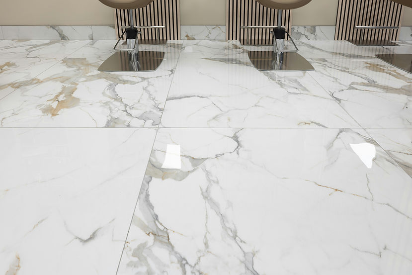 Sleek marble floor tiles with gray veining and polished finish reflect light