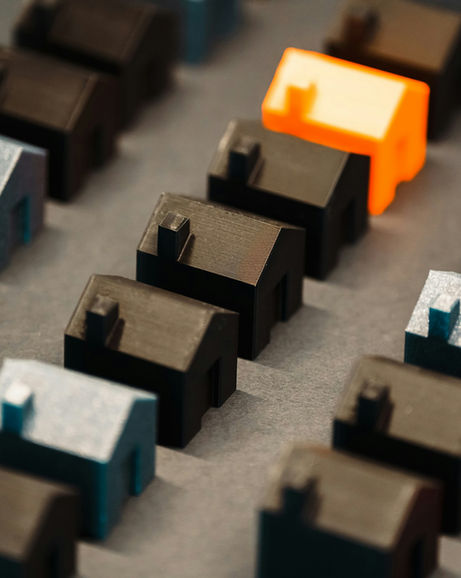 A group of alined plastic figurines on the shape of homes.