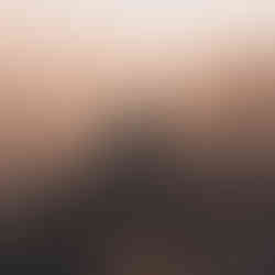 A traveler with a backpack sitting on a rocky peak at sunset, overlooking the misty valley of the Galilee.