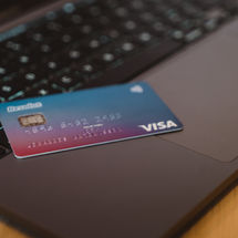Carte Revolut Visa posée sur le clavier d’un ordinateur portable, symbolisant une gestion bancaire digitale et mobile.