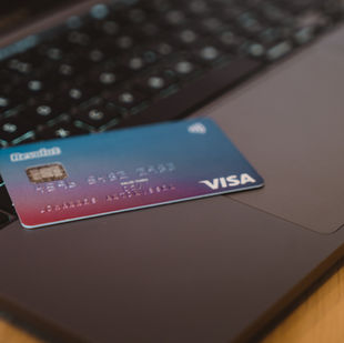 Carte Revolut Visa posée sur le clavier d’un ordinateur portable, symbolisant une gestion bancaire digitale et mobile.