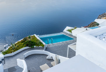 View of building building with blue swimming pool overlooking the open ocean