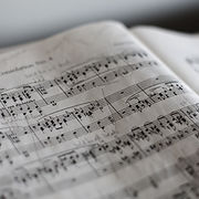 A blurred generic image of a piece of manuscript (music) paper.