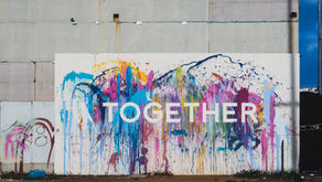 A vibrant public art installation features a splash of rainbow colors with the word "Together" boldly displayed, symbolizing unity and collaboration.