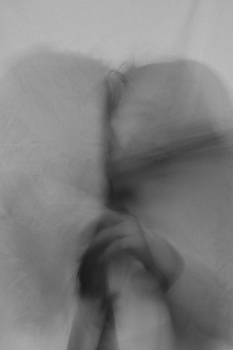 Blurred monochrome image suggests movement, with a faint outline of a person's face and hands. Mysterious, dreamlike atmosphere.