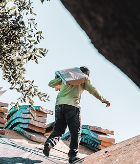 Roofer standing on the roof of a brick home during tear-off for a roof replacement