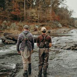 Two men on wading a river.