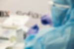 Healthcare worker in protective gear conducting lab work — image symbolizing comprehensive primary care services.