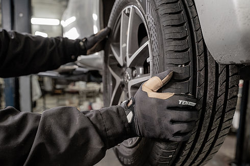 A Technician Replacing a Flat Tire With a New Tire