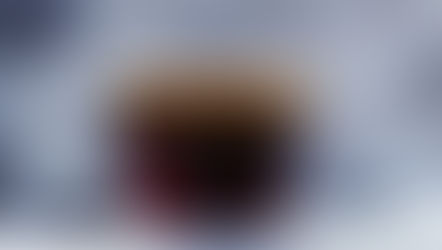 Cozy glass cup of hot coffee on snowy wooden railing with blurred winter forest background, evoking serene caffeine-free morning ritual for seasonal focus and calm.