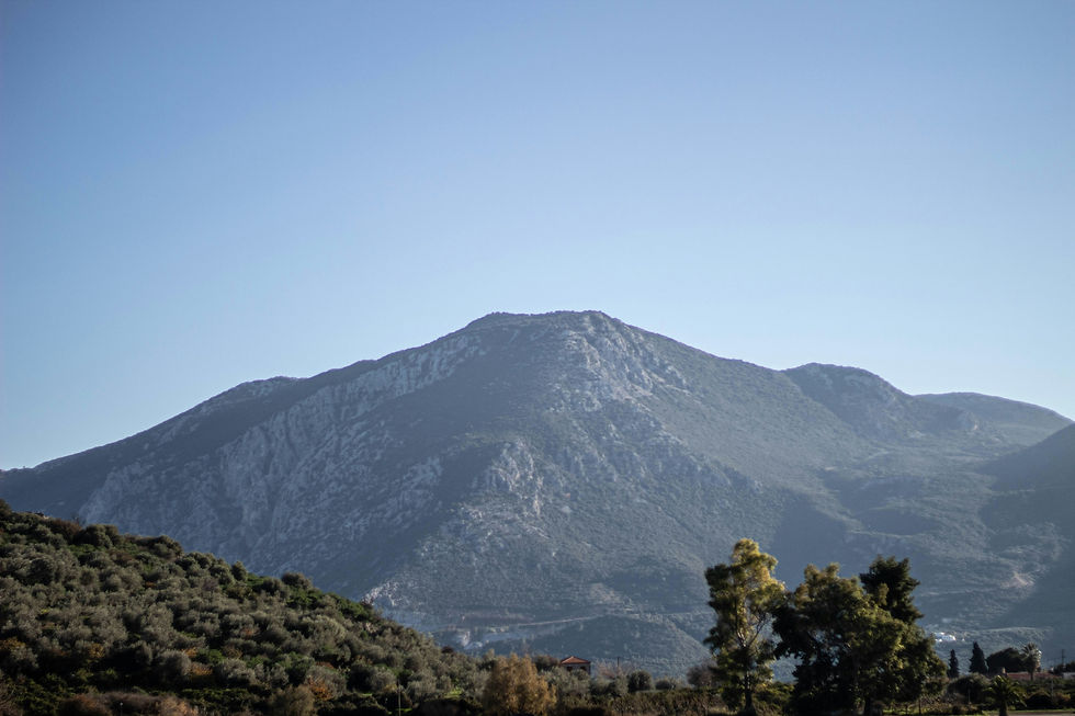 Mountainous landscape with olive groves and clear views of the highest peak in the Hydra region.