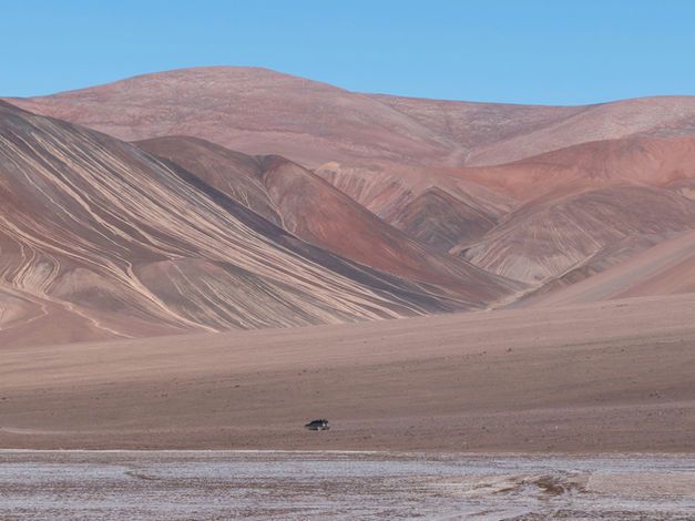 Imagem de um deserto com uma lagoa azul no deserto do atacama