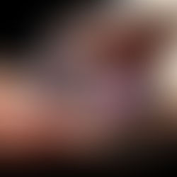 A vibrant butterfly with purple, orange, and black patterns rests gently on an open palm against a dark background, conveying a serene mood.