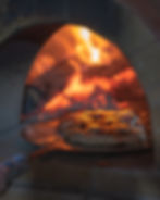 Food being cooked in a wood-fired oven