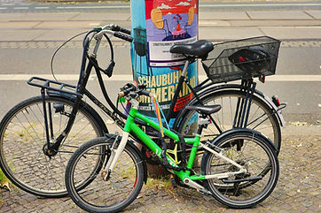 Zwei Fahrräder parken an einer Säule mit einem Plakat im Freien.