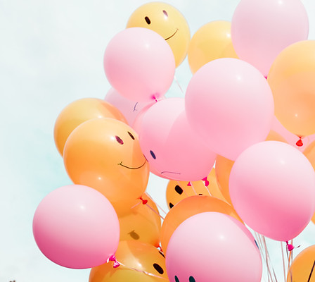 Rosa und Orangenen Luftballons die gebündelt in den Himmel ragen