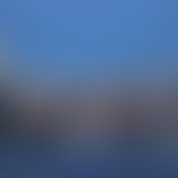 Manhattan skyline at dusk viewed from across the water, featuring Midtown skyscrapers including slender luxury towers along Billionaires’ Row under a clear blue sky.