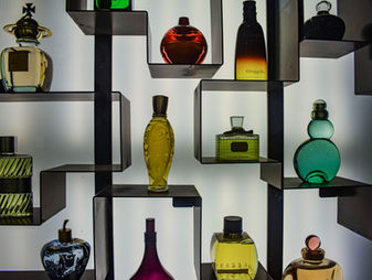 Collection of luxury perfume bottles on geometric shelves
