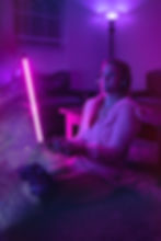 Woman plays video game at home with pink light