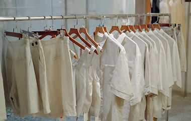 Freshly pressed commercial uniforms on a rail at Laundrette by Fast Cleaning Dundee, colours consistent and logos protected, prepared for labelled distribution.