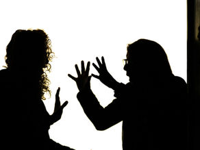 Two women arguing. One has her hands in front of her face.