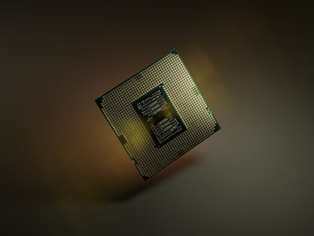A close-up of a computer processor with intricate patterns, floating against a dark, blurred background, highlighted by a soft glow.
