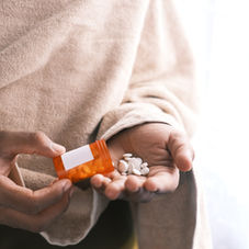Pills being spilt into palm from the bottle