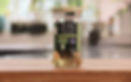A bottle of anchovy filets in olive oil in a jar on a wooden table.