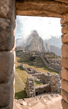 Ancient mountaintop ruins framed by a stone window at first light