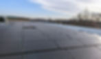Eye-level view of a commercial building roof with new roofing materials