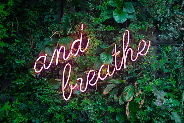 A wall sign that says "and breathe"