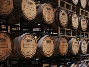 Wooden whiskey barrels stacked on racks at St. Augustine Distillery in Florida