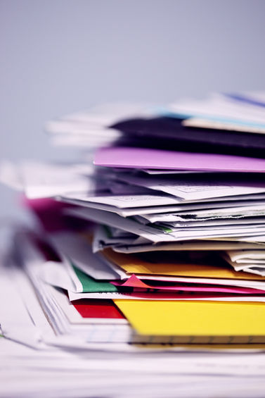 Stapel von Papieren: Dokumente in verschiedenen Farben, berufliche Aufgaben.