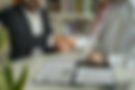 two businessmen shaking hands over a contract