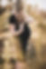 Pregnant woman in a back dress, standing in a wheat field on a sunny day