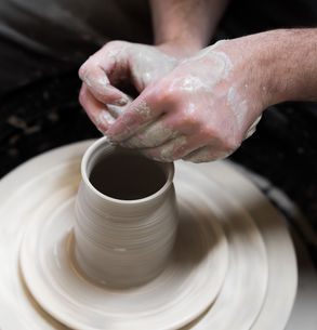 Pottery wheel class in Munich. Hands shaping clay on a spinning wheel