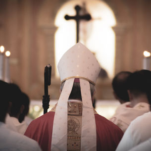A Bishop and others, seen from behind processing toward an altar