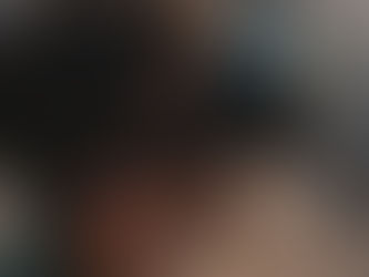 Person wearing VR goggles outdoors, looking up. Brown hair, patterned shirt. Sunny day, blurred natural background evokes exploration mood.