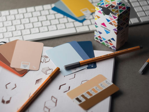 Colour swatches and logo designs on a desk