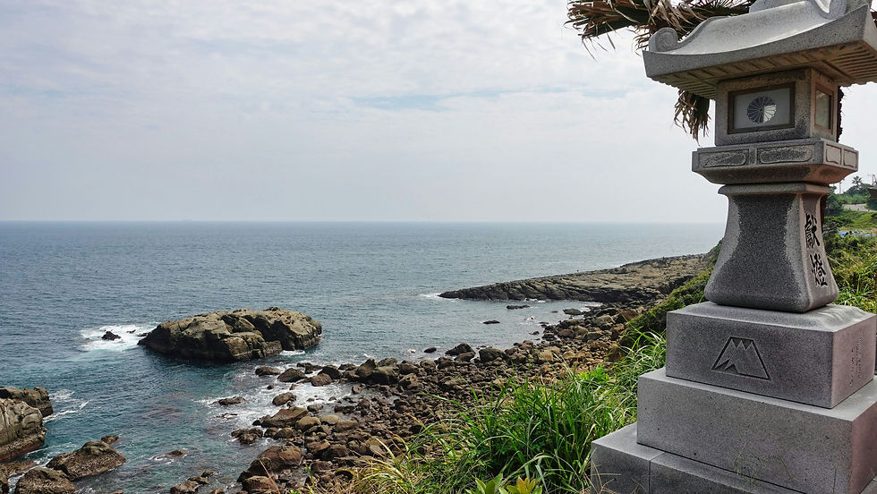 Eye-level view of Udo Shrine entrance carved into cliffside with ocean in background