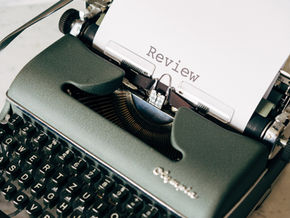 Typewriter with paper saying the word review