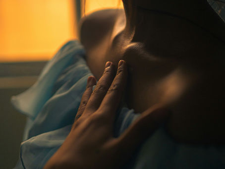 A woman resting her hand on her chest in quiet natural light — perimenopause heart palpitations are driven by estrogen's role in the heart's electrical conduction system