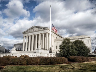 US Supreme Court with the US flag at half mast
