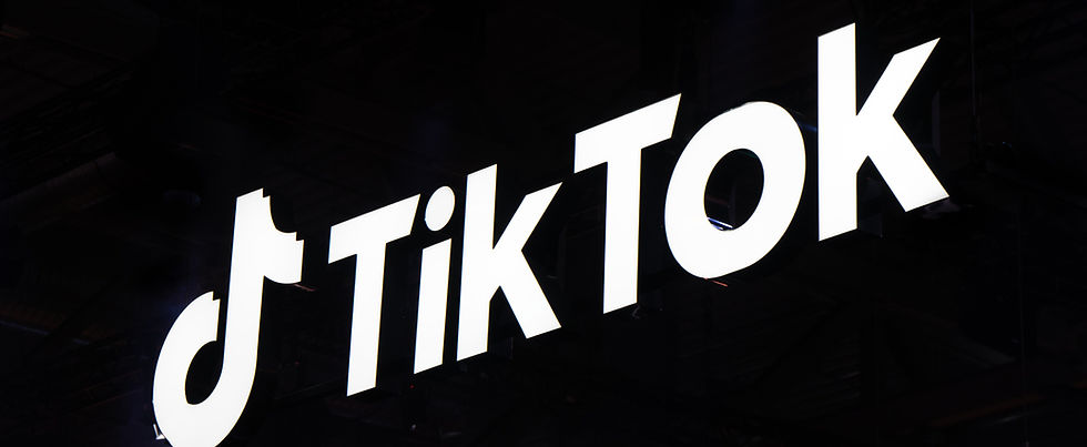 Large illuminated TikTok logo and text displayed on a dark background, featuring the signature musical note symbol and bold white letters spelling "TikTok.
