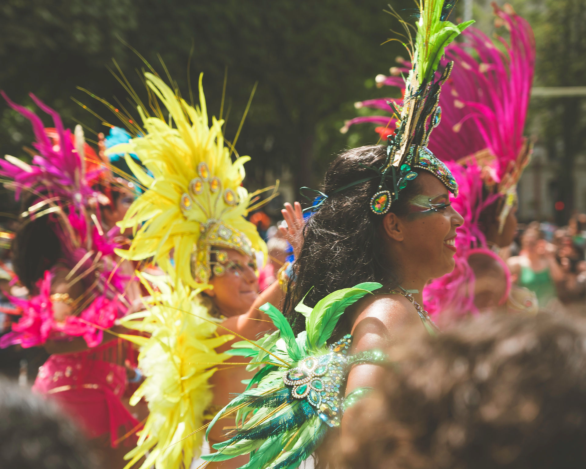 Group of girls dance in the street in Rio in bright feather costumes